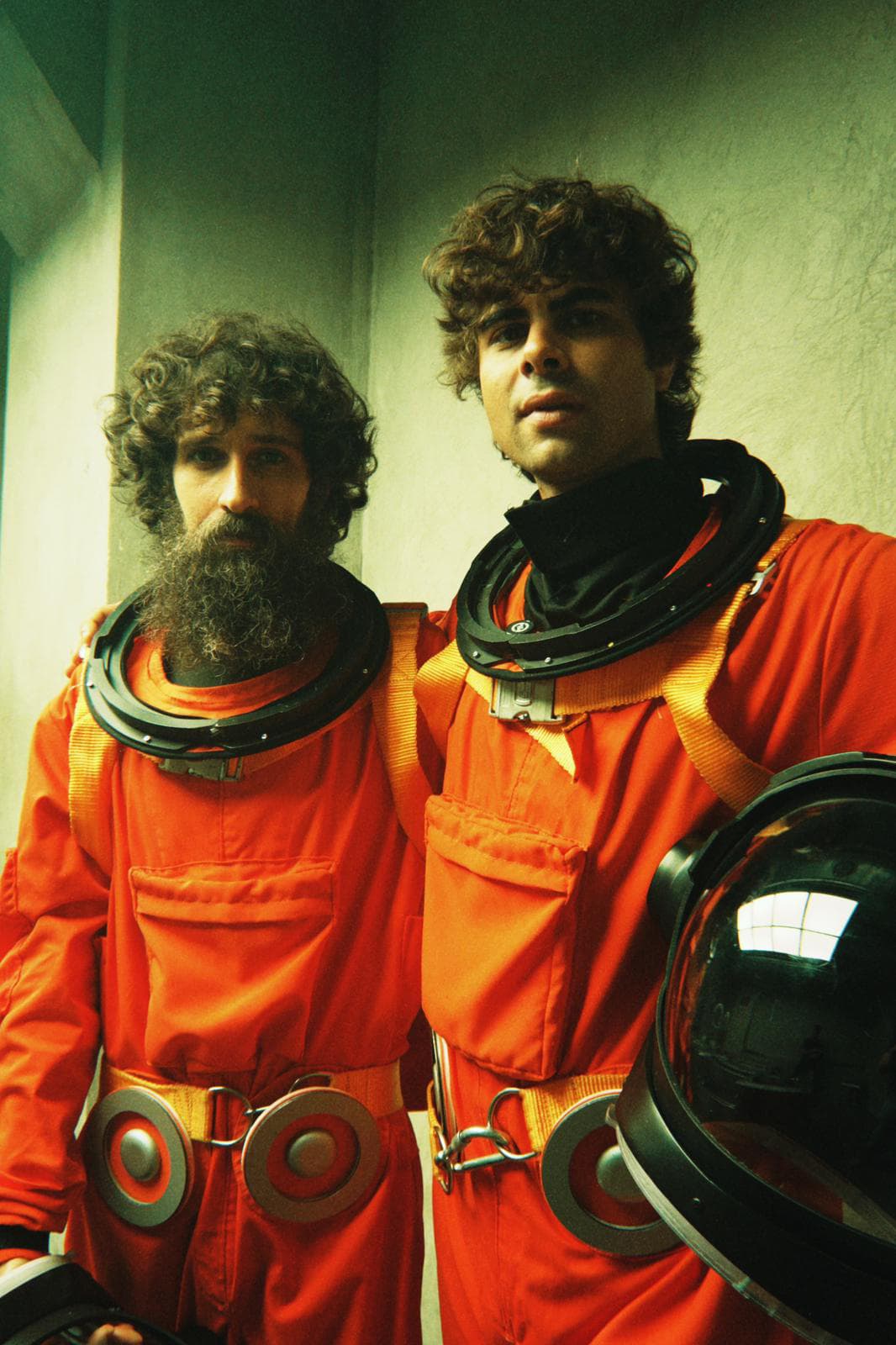 Sarria y Ángel Stanich vestidos con monos naranjas de astronauta en el rodaje del videoclip